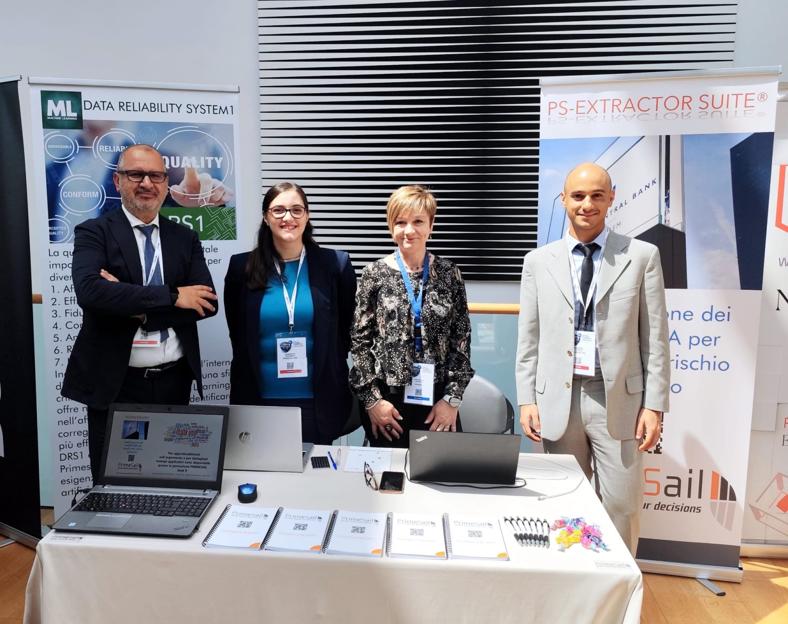 Quattro persone del team PrimeSail in piedi allo stand aziendale.